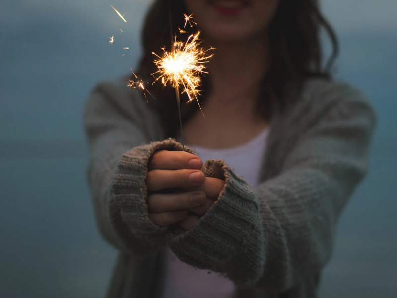 A young girl holds a sparkler