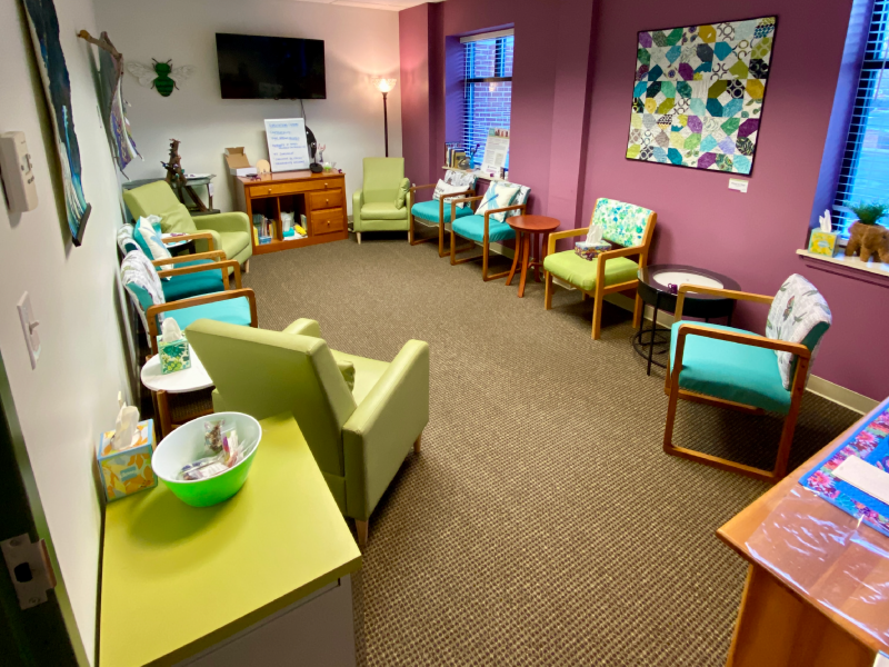 A room with chairs, bright walls, and colorful artwork used to facilitate support group sessions